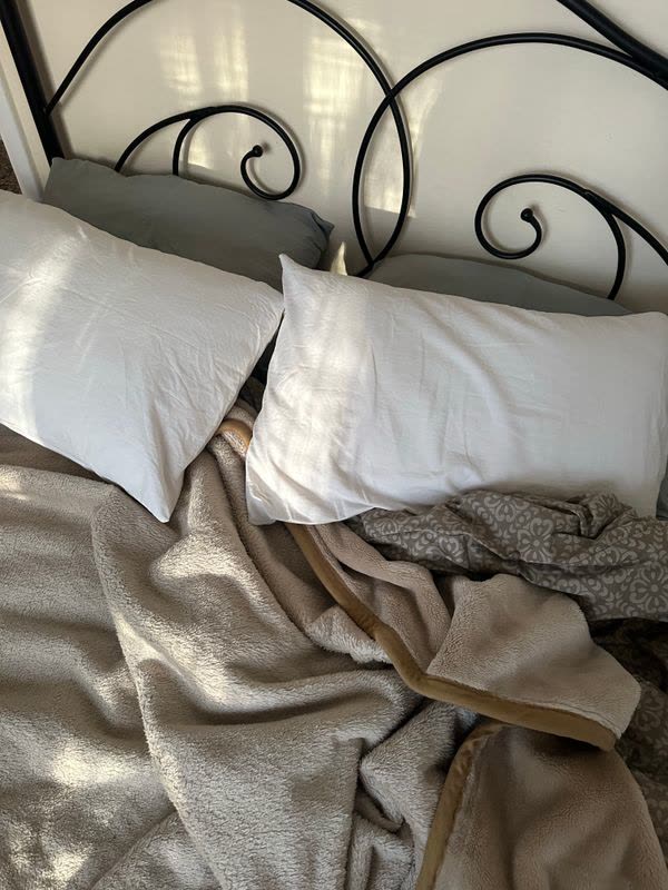 Unmade bed with white pillows in the morning
