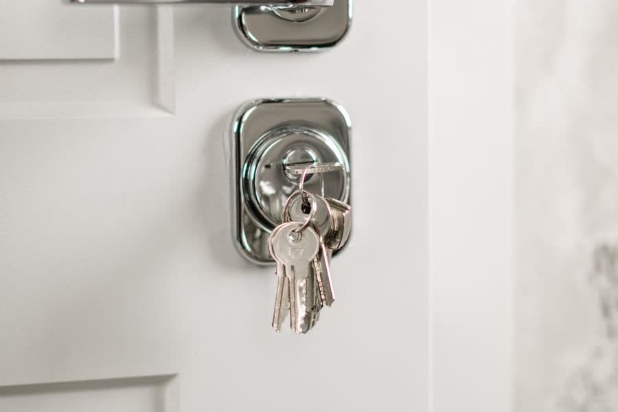Keys hanging in the lock of a white suite door