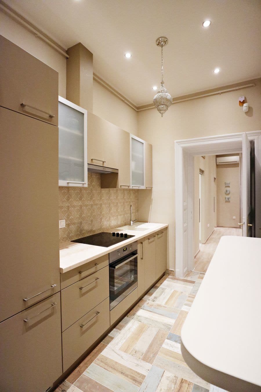 Galley kitchen with a cooktop, oven and tall cabinets