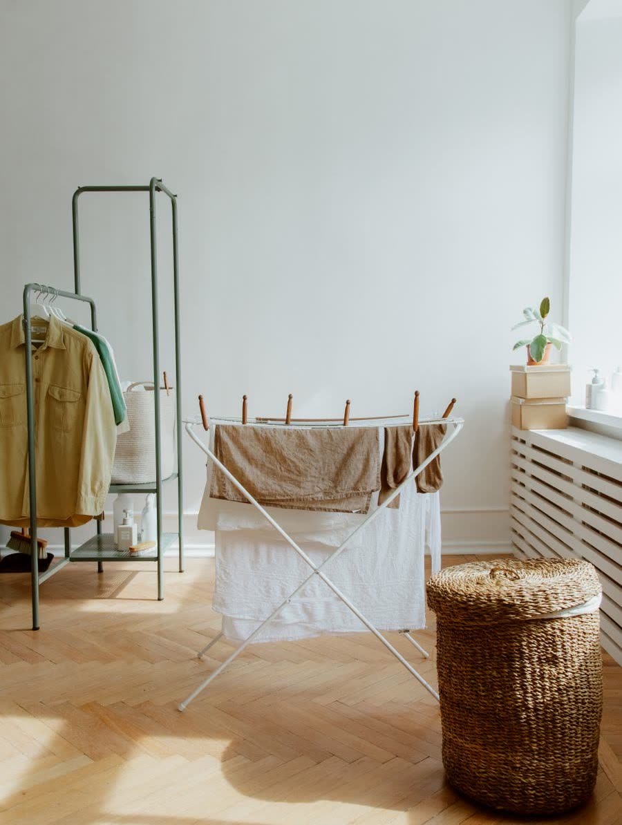 Drying rack and a woven laundry basket in a sunny room