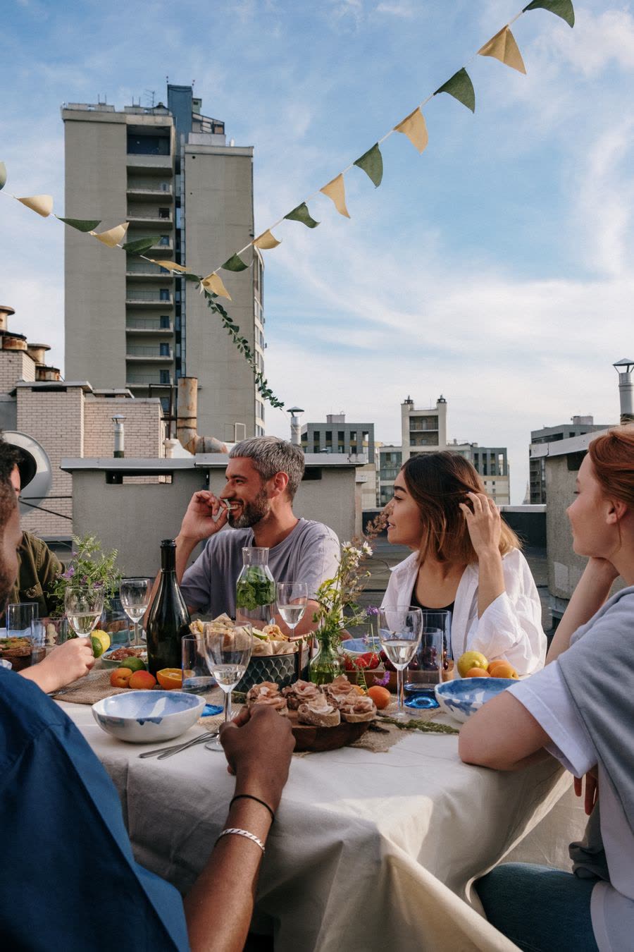 Guests sharing a meal at a long table on the roof deck