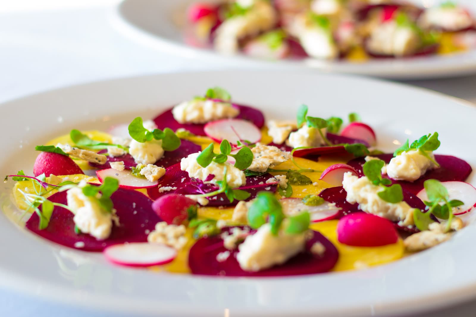 Roasted beets with citrus, feta and herbs on a white plate