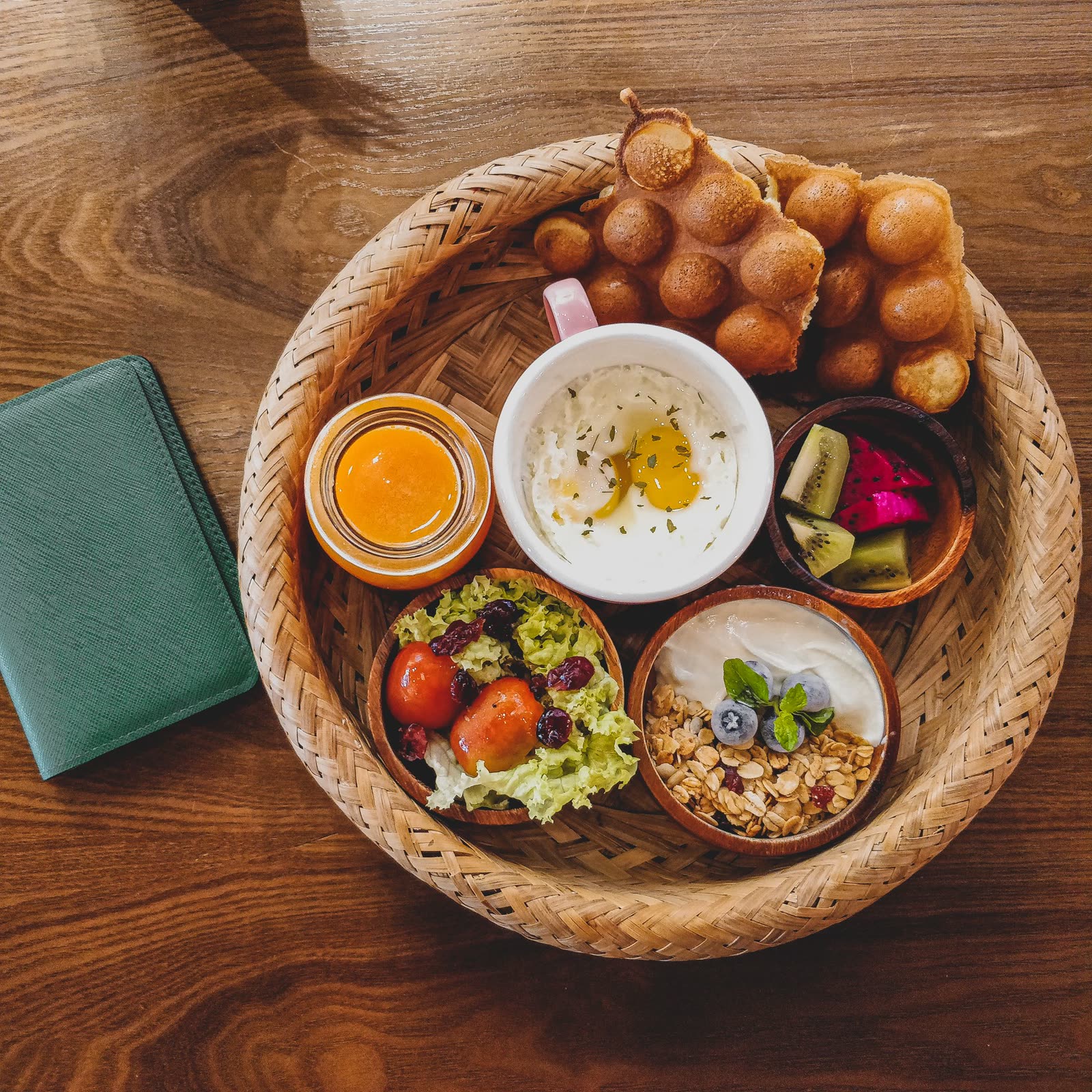 A brunch table set with yogurt and berries, eggs, pastries and cold drinks
