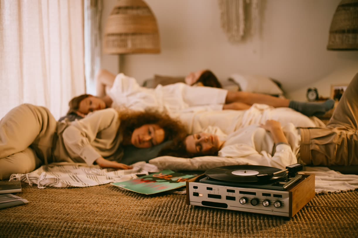 Friends lying on a rug next to a record player