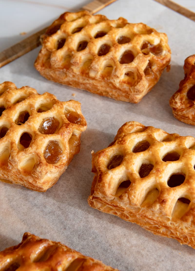 Rows of lattice-top guava pastelitos on baking paper