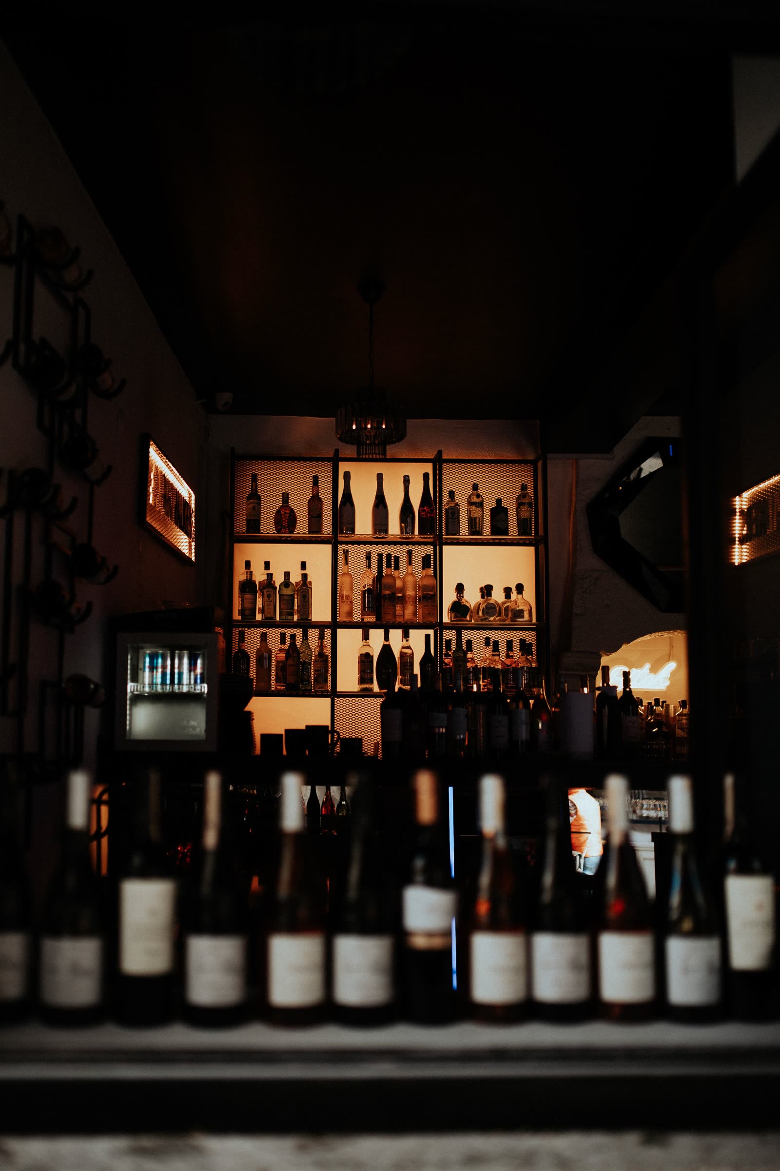 The bar at COPPER LANTERN with its lit back bar and shaded lamps
