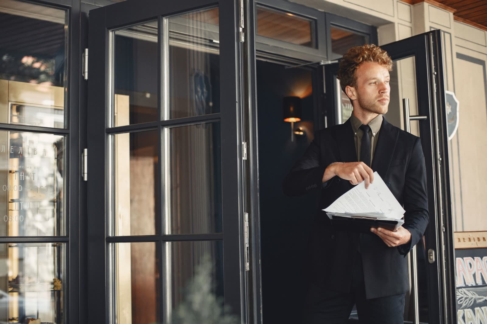 A host in a tuxedo and bow tie at the door of COPPER LANTERN