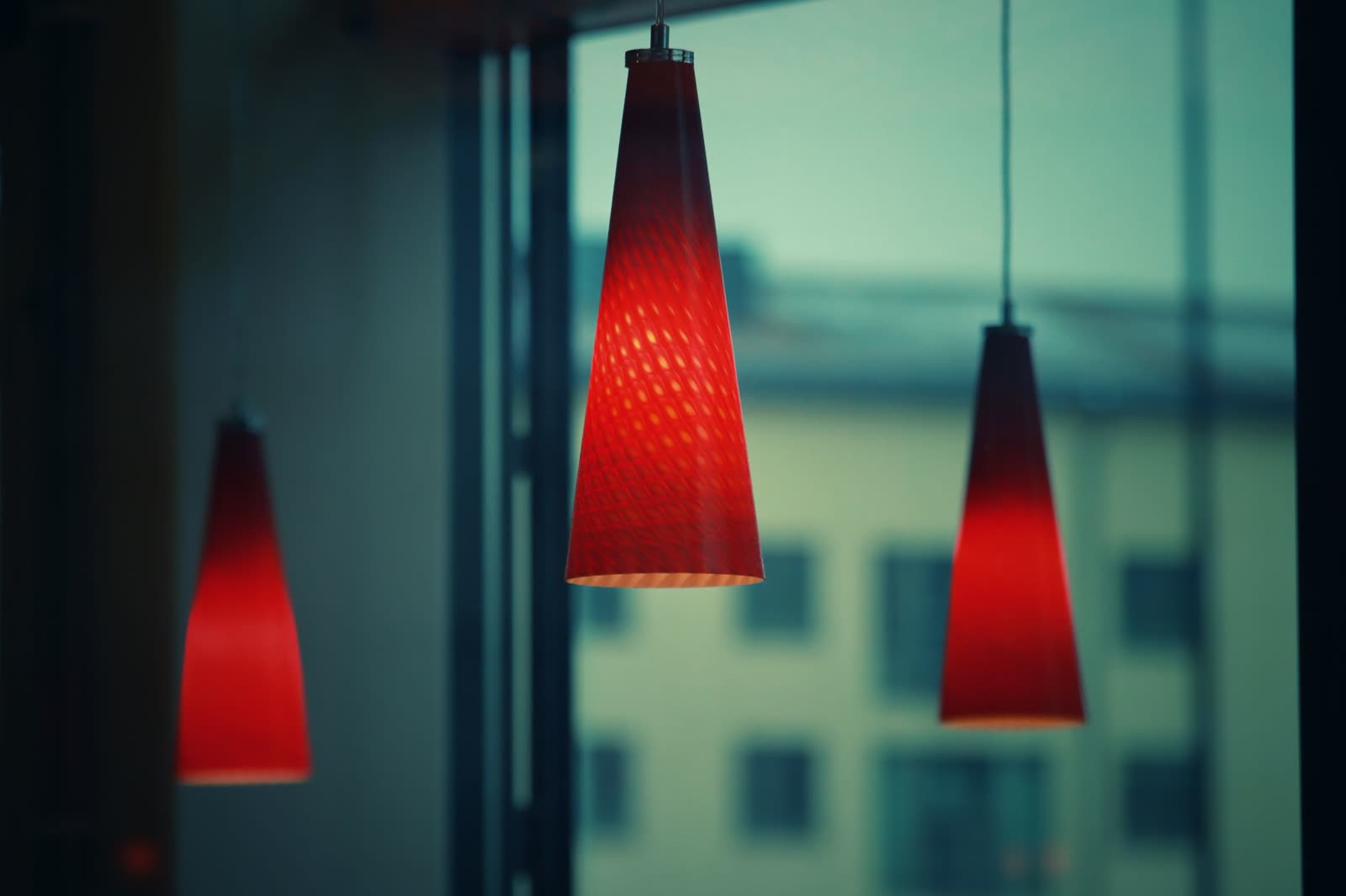 The long banquette at COPPER LANTERN set with candles and red-shaded lamps