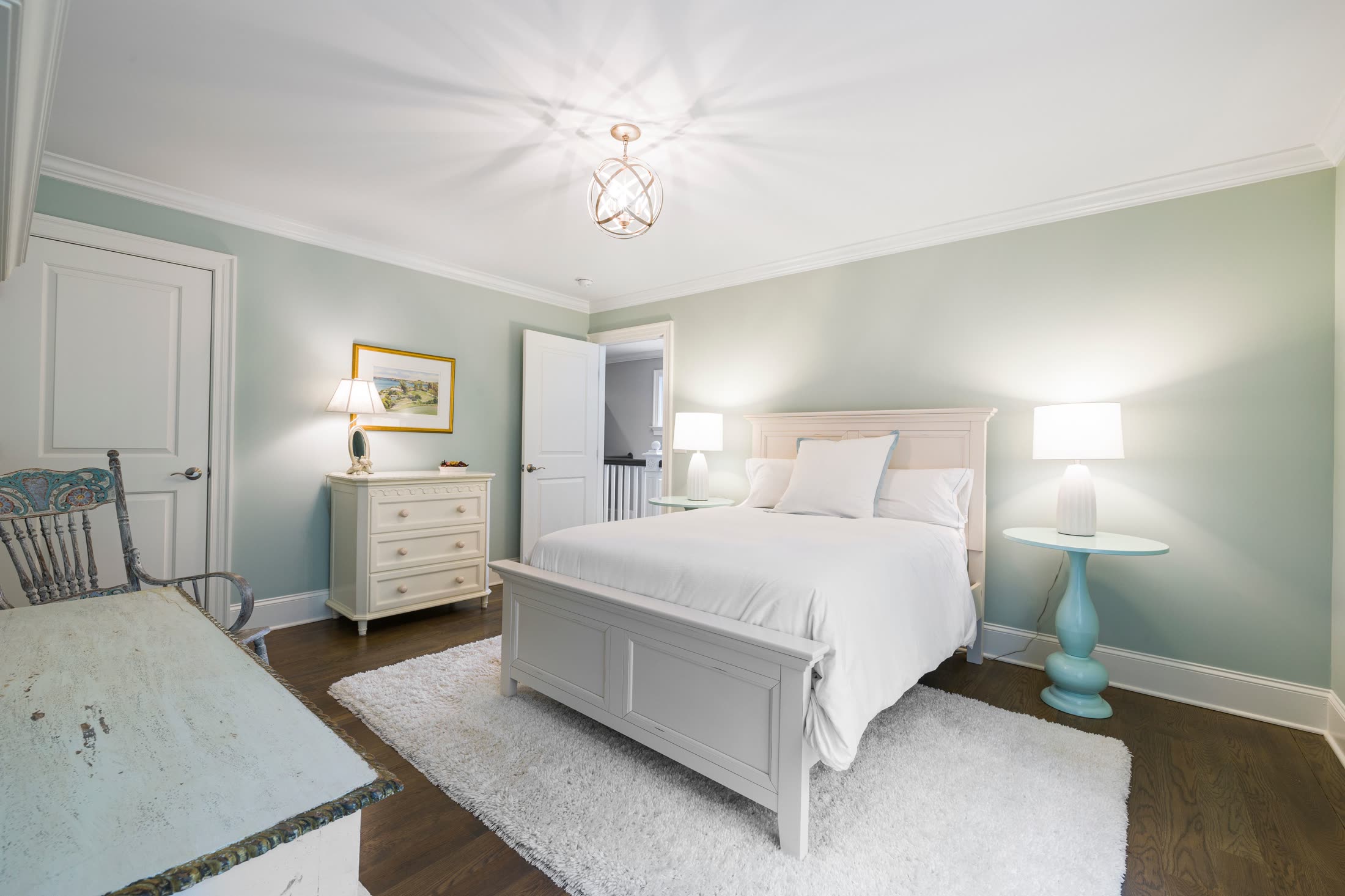 Soft white bedroom with a rug and bedside lamps