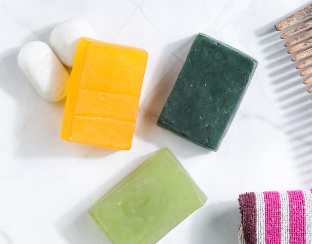 Orange, green and sage soap bars on white marble