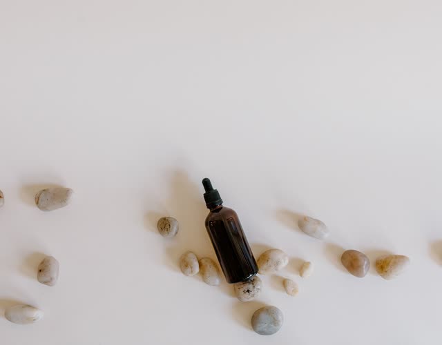 Amber dropper bottle among small stones