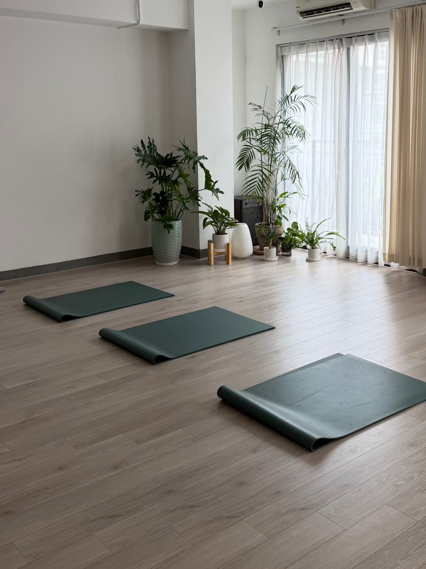 Three green mats laid out in an empty studio before class