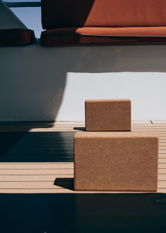 Two cork yoga blocks stacked on a wooden deck