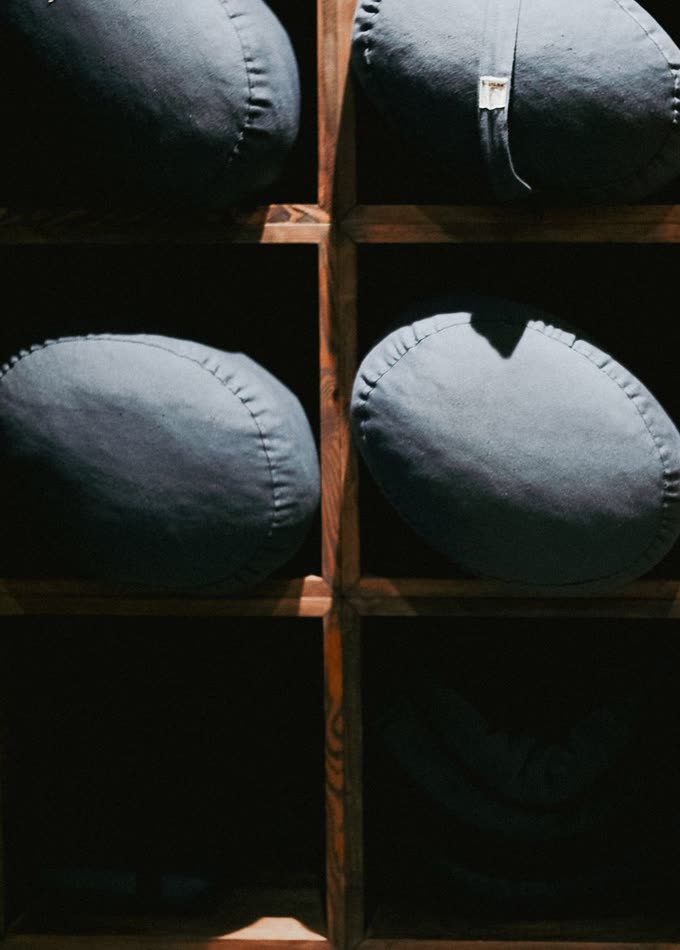 Round cotton bolsters stacked in wooden cubbies