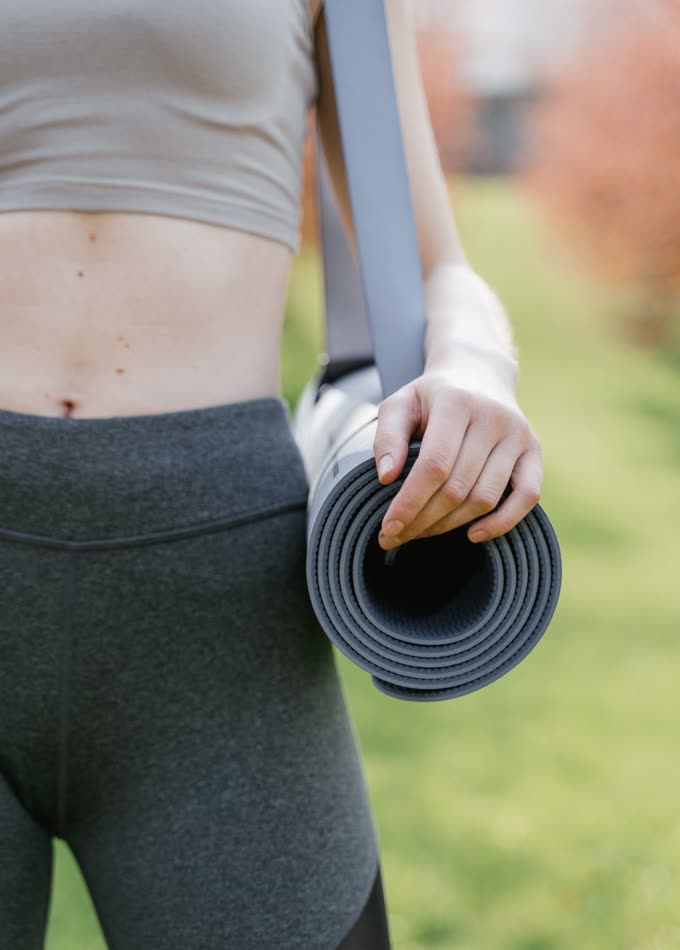 A rolled mat carried on a shoulder strap