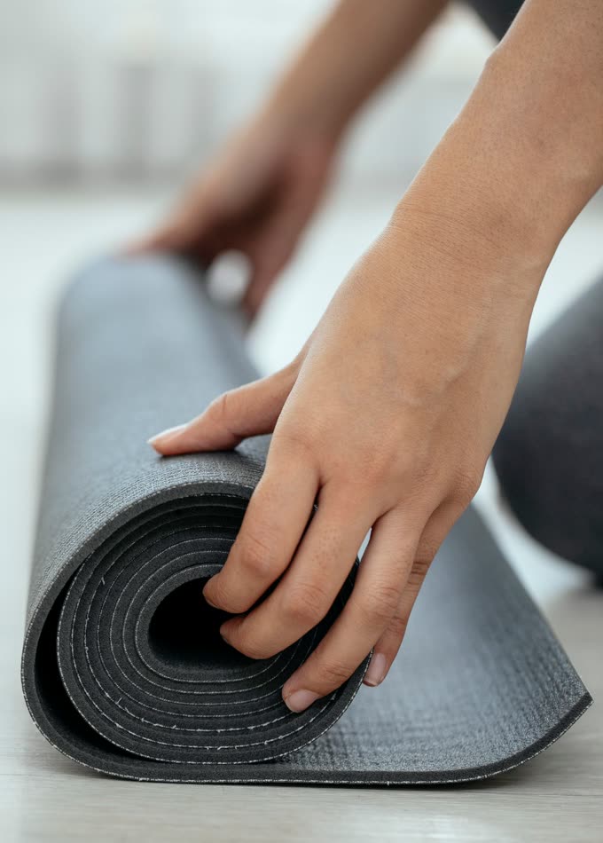 Hands rolling a grey mat