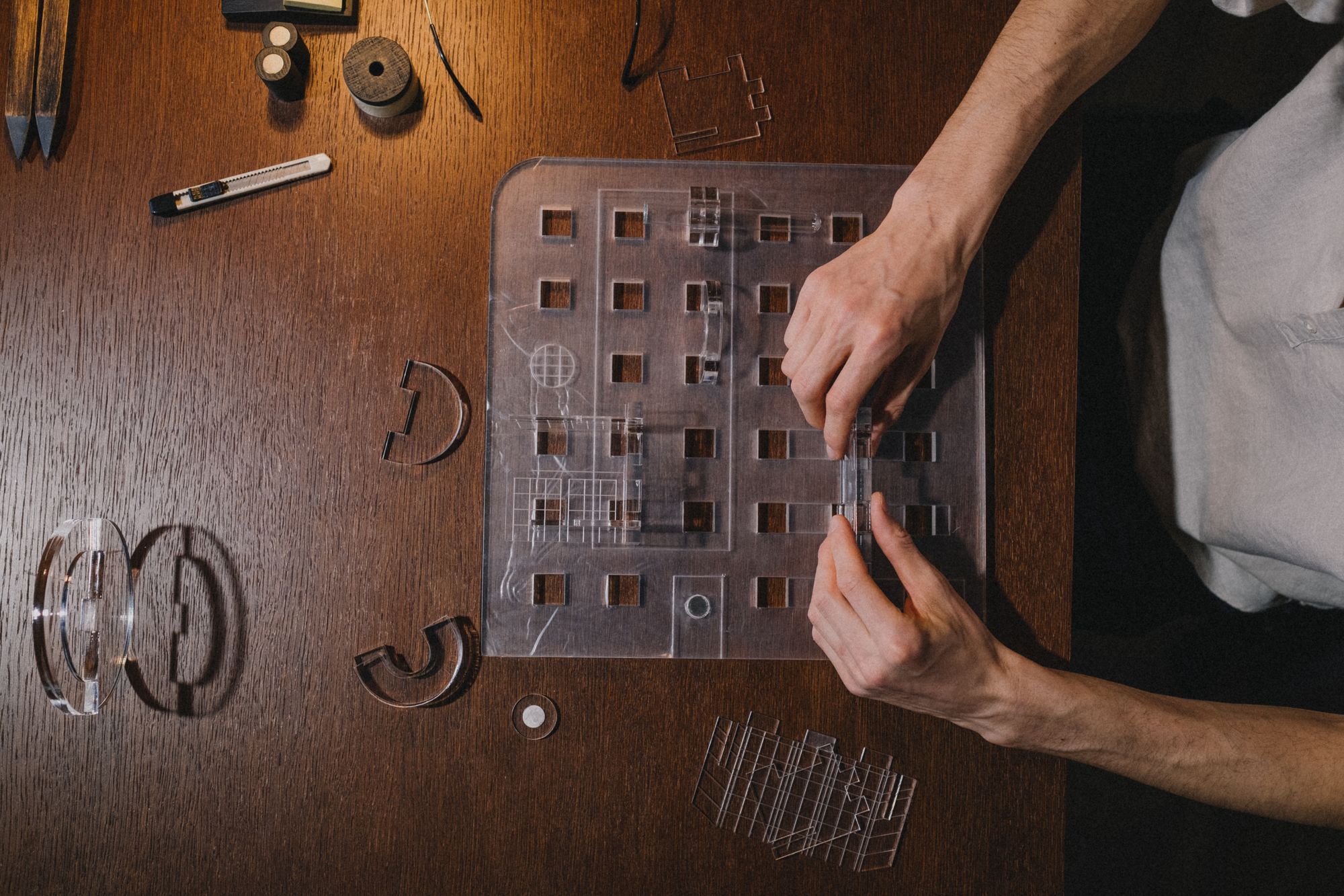 Laser-cut acrylic tray parts laid out on a desk