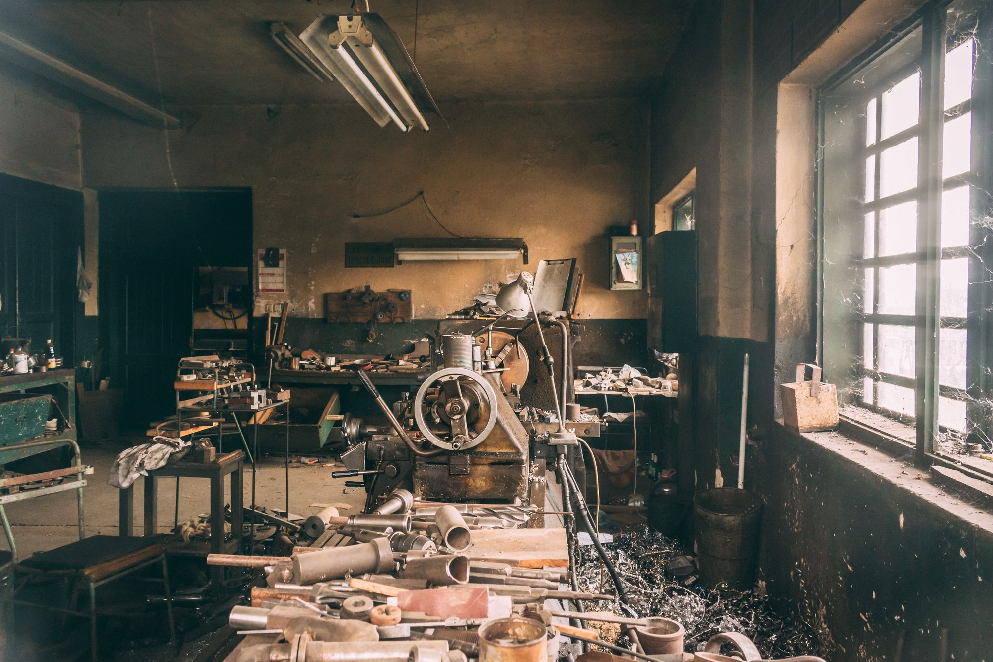 A machine shop with lathes and a workbench by the window
