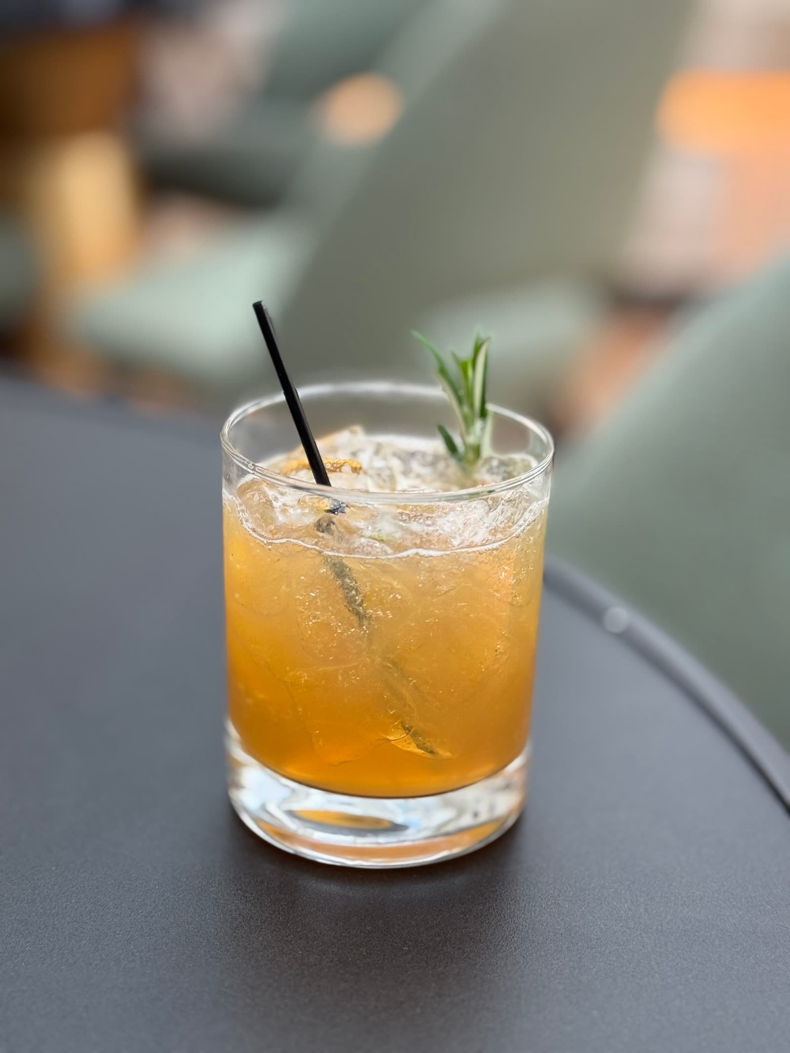 A craft cocktail with rosemary on the HOLLOW FIG bar