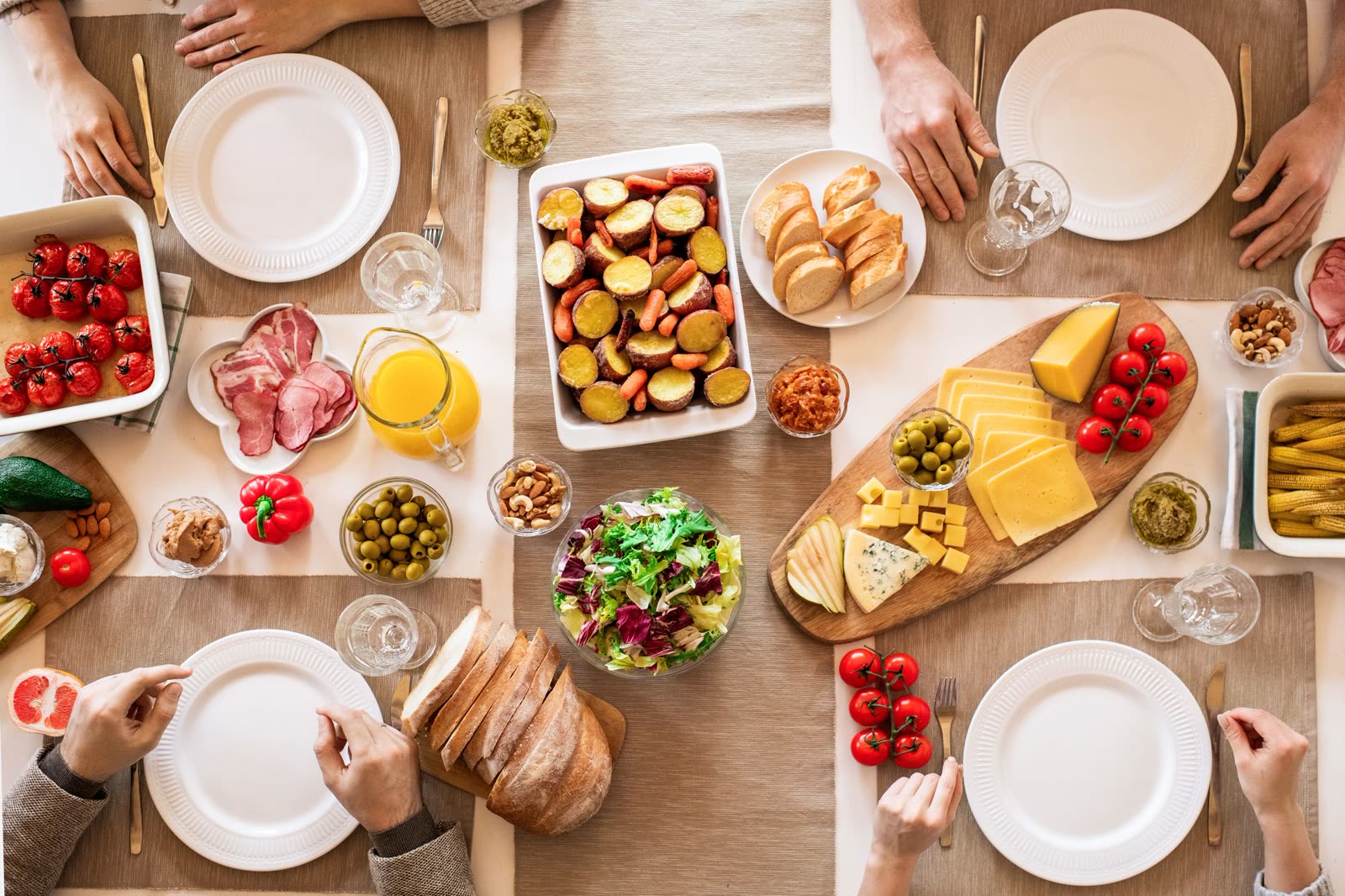 An overhead spread of HOLLOW FIG plates, bowls and drinks on a wooden table