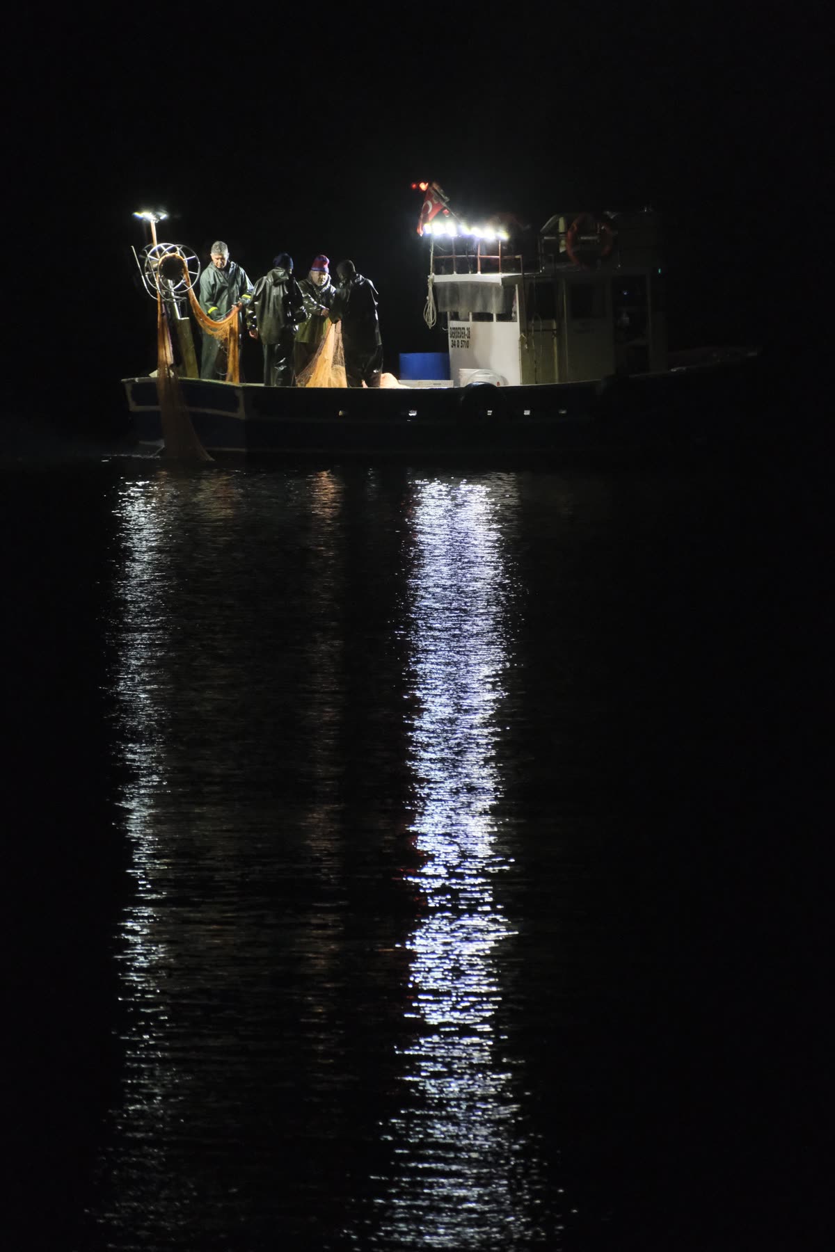夜の海に浮かぶ漁船の明かり