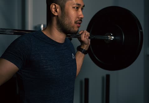 バーベルを肩にかついだトレーナー