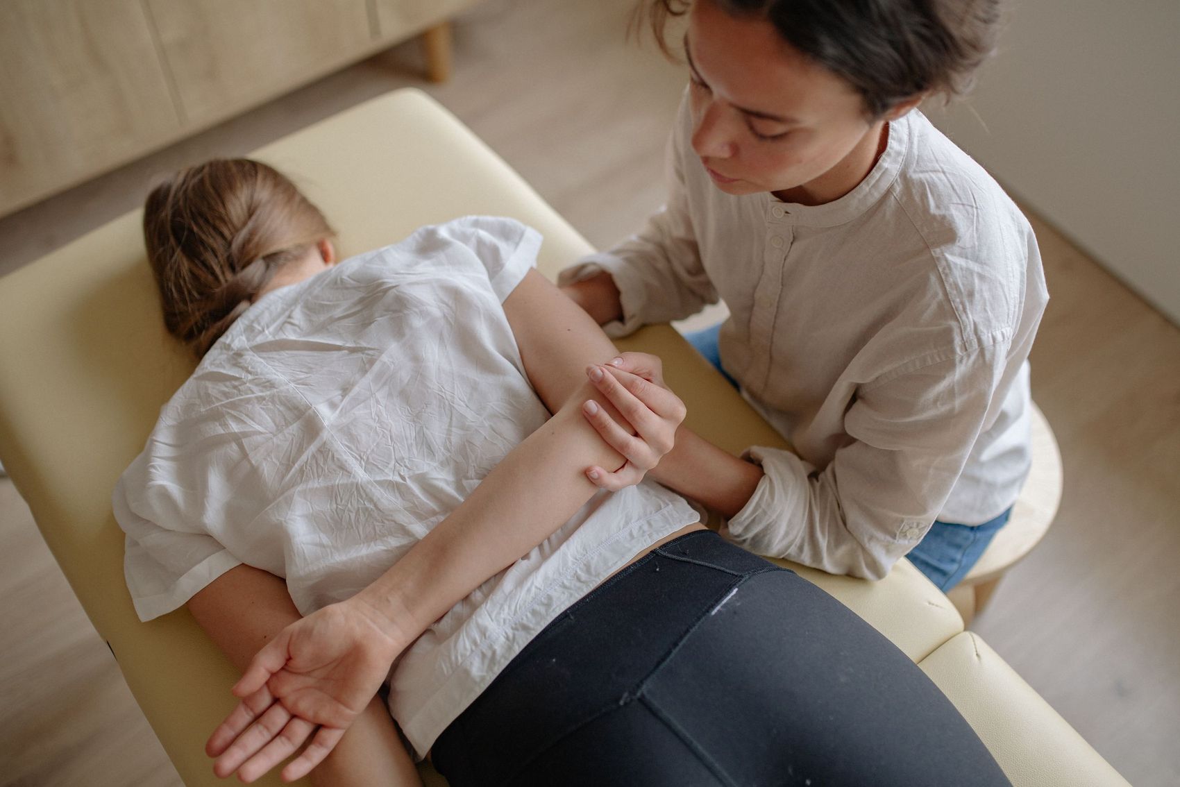 施術台の上で腕と肩の動きを確かめている施術者