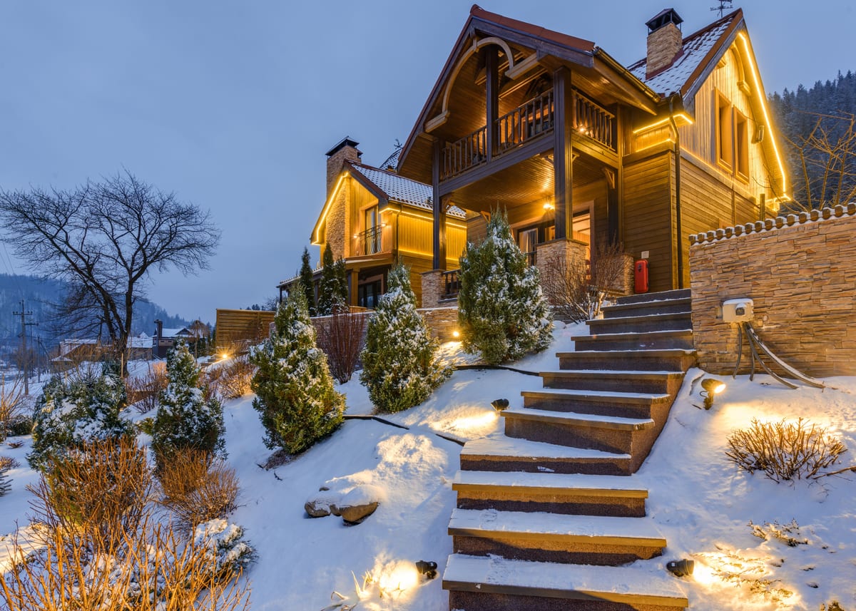 雪をかぶった木の家と石段のテラス小屋
