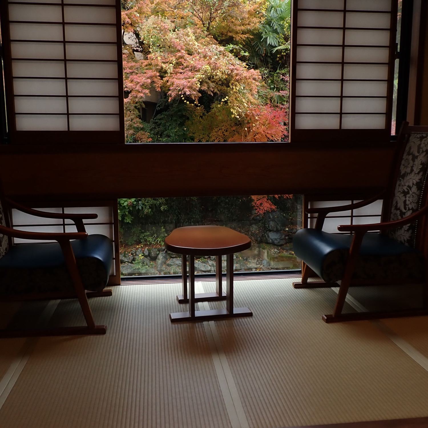 椅子を二脚置いた和室。窓の外にもみじが色づいている。