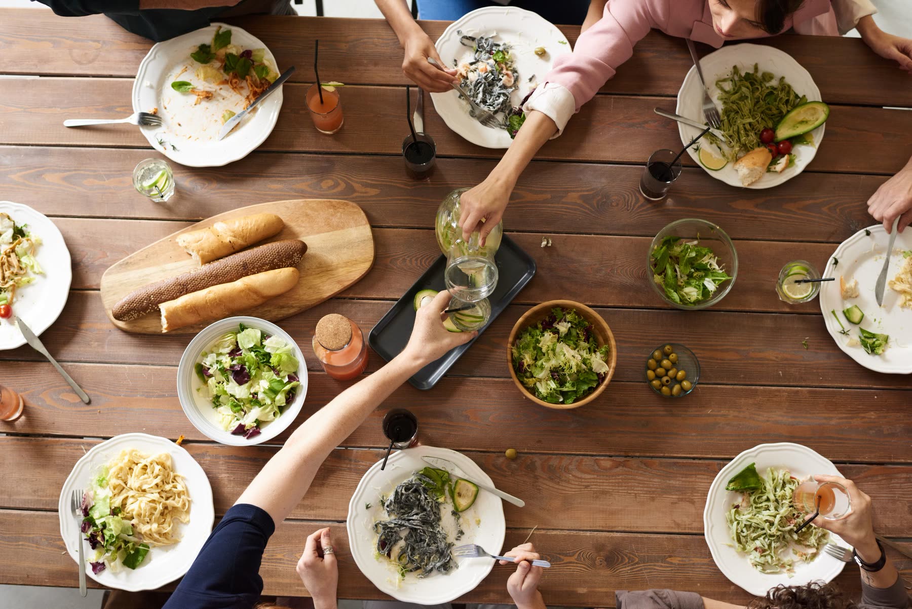 A long wooden table of shared plates seen from above