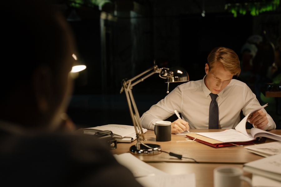 An analyst marking up a printed report at night