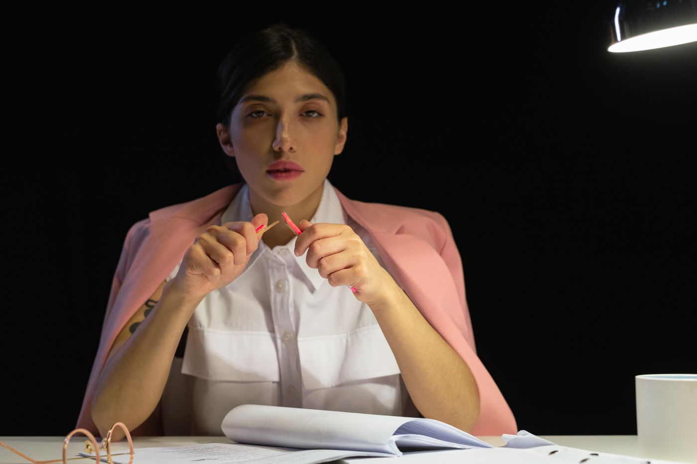 An analyst at a desk lamp with a printed report