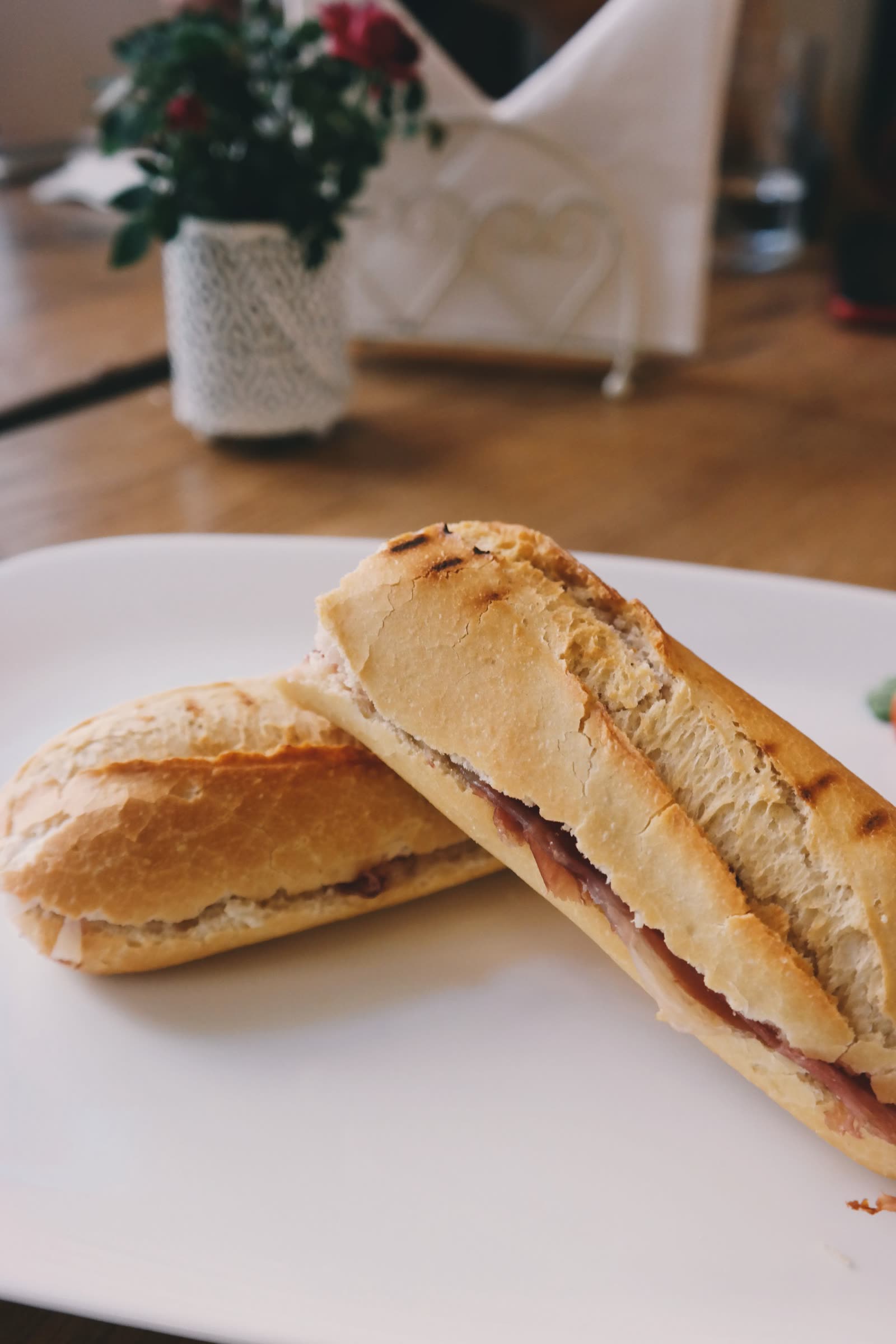 A jambon beurre baguette with a ramekin of butter on the marble counter