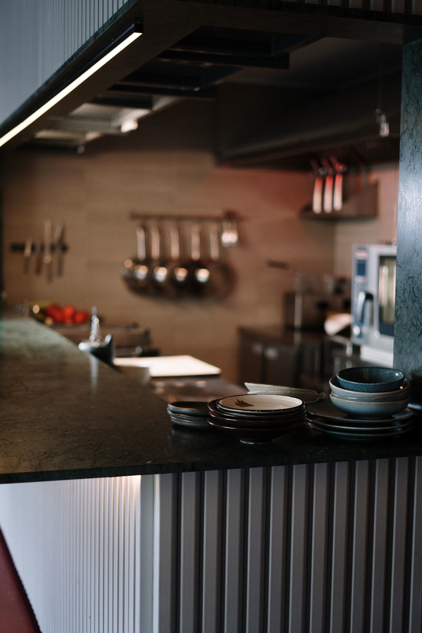 A plate of duck confit being set down on the marble counter