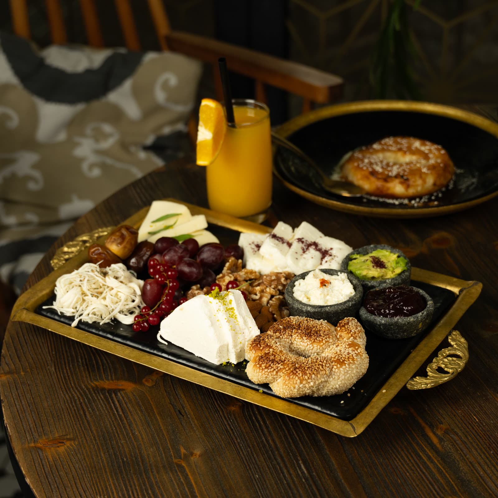 A cheese plate with cornichons and baguette