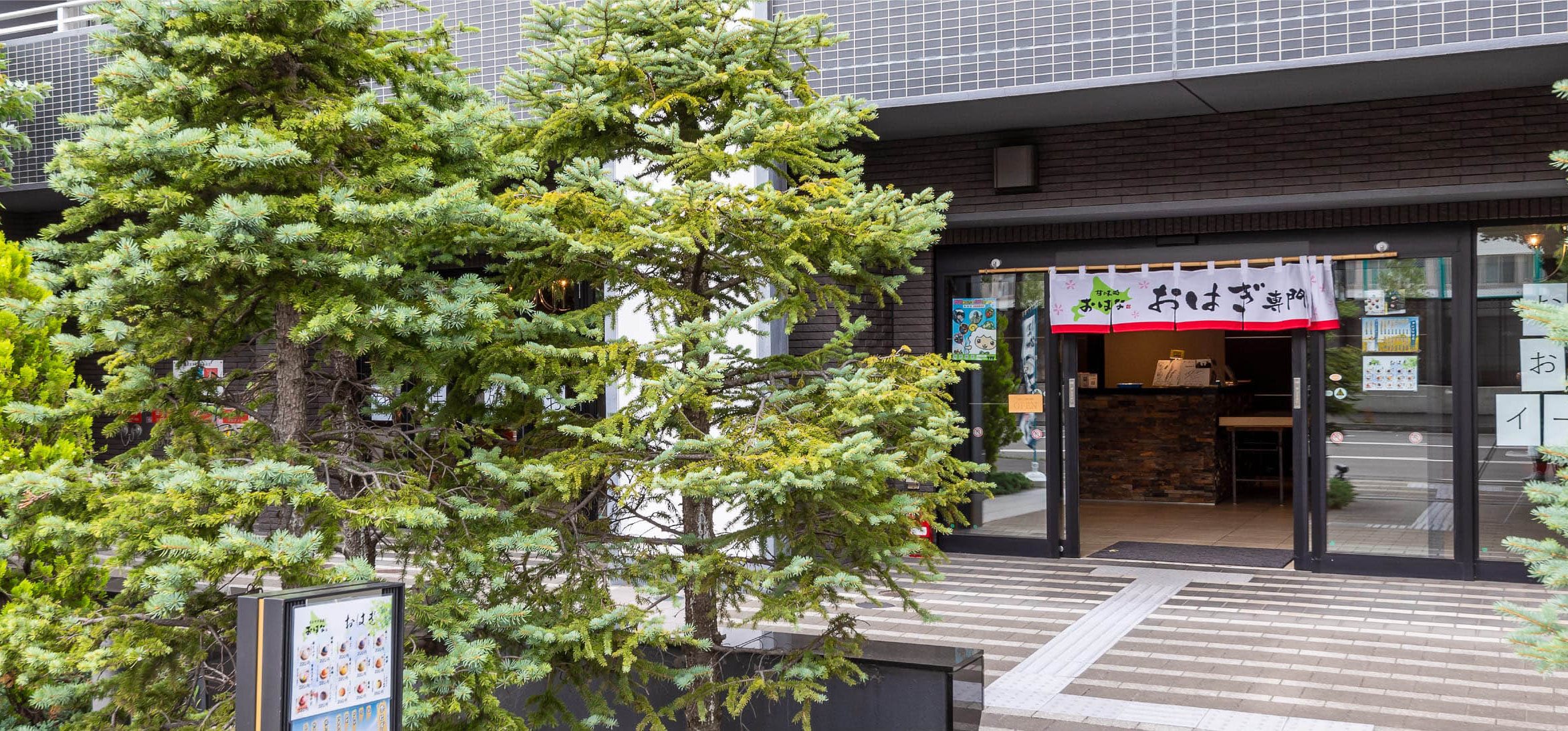 木立の奥にあるお店の入口（お店の写真）