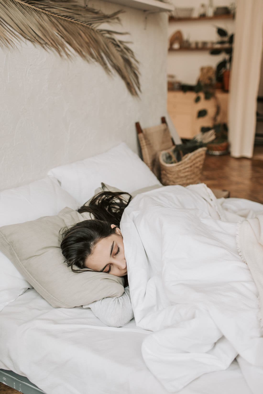 A woman asleep under a white duvet