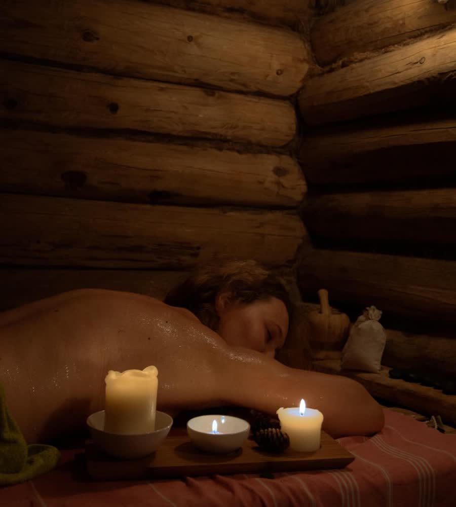 A massage by candlelight in a log-walled treatment room