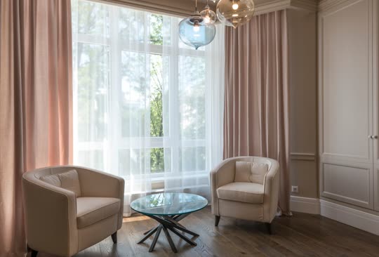 Two armchairs facing each other by a tall window